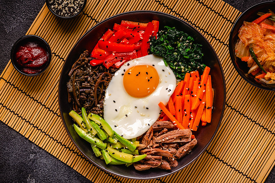 Traditional Korean dish Bibimbap: rice with vegetables beef and egg, top view image
