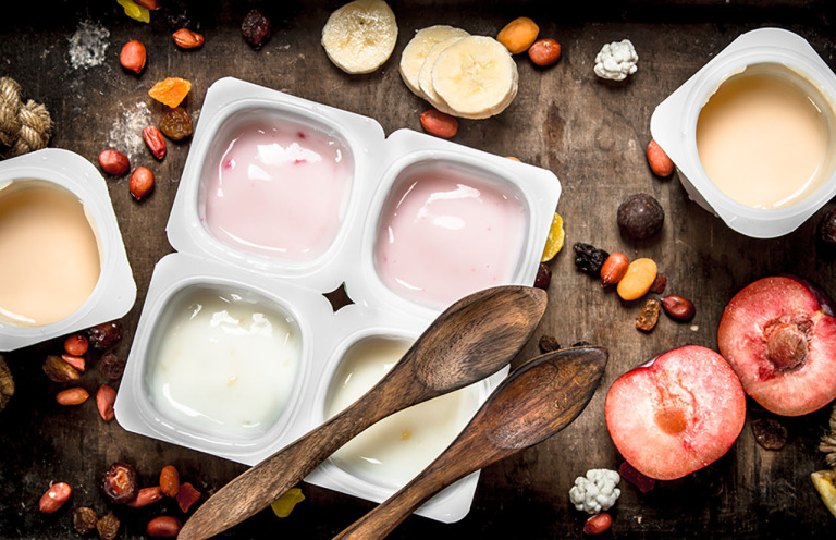 Various fruit yoghurts on a wooden background image