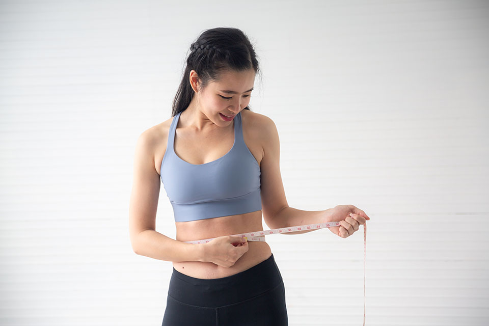 Young Asian woman measure body proportions, health fitness to slim body concept image